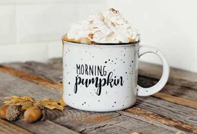 A mug of pumpkin spiced coffee topped with whipped cream and cinnamon