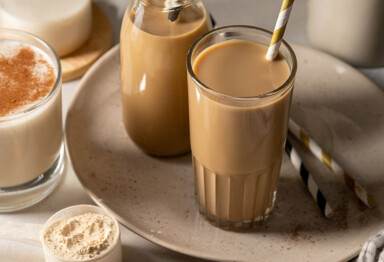 Glasses filled with keto iced coffee protein shake next to collagen scoop