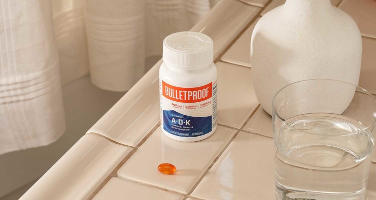 Bulletproof Vitamins A-D-K on counter next to softgel