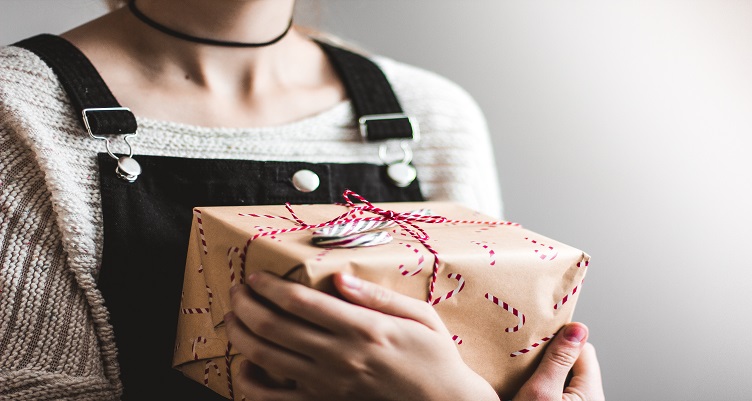 Person holding a wrapped holiday gift