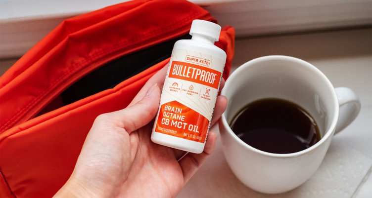 A travel-size Brain Octane Oil and a cup of coffee