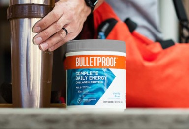 A man holding a gym bag and protein shaker, along with a tub of Bulletproof Complete Daily Energy Collagen Protein