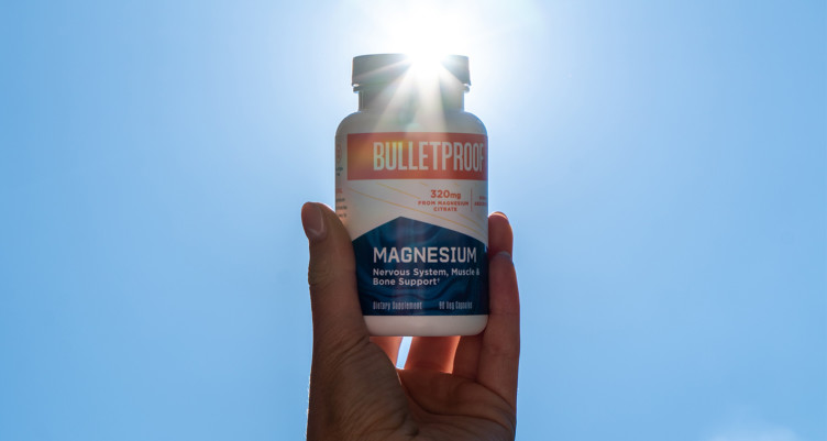 Holding up a bottle of Bulletproof Magnesium