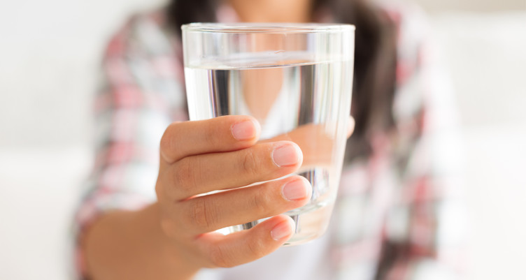 A woman holding a glass of water