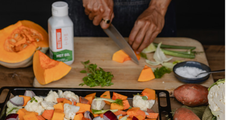A person preparing dinner with a bottle of Bulletproof MCT Oil 
