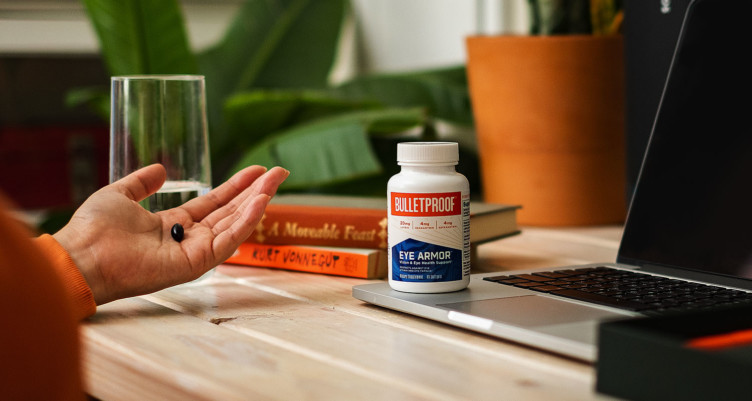 A hand holding a Bulletproof Eye Armor supplement