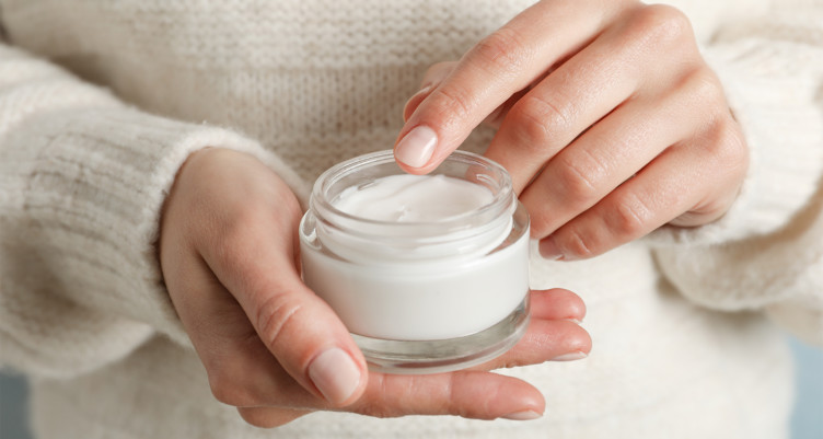 Woman holding jar of moisturizing cream