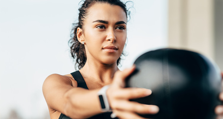 A woman lifting a medicine ball