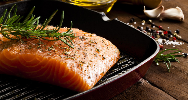 A seasoned salmon steak in a cast iron skillet