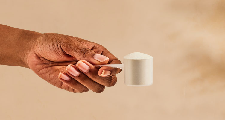 hand holding scoop of unflavored collagen peptides