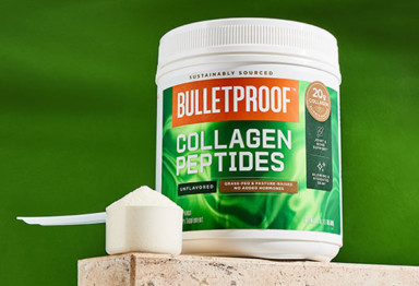 a scoop of unflavored collagen peptides sits on a counter with a green background