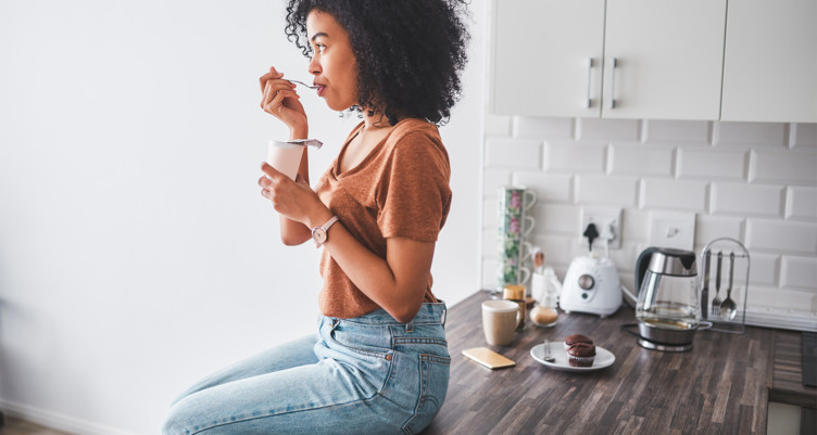 Woman eating while sitting on countertop