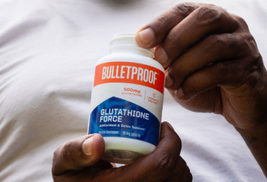 Two hands holding a bottle of Bulletproof Glutathione Force