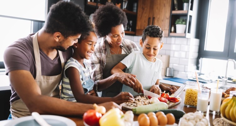A black family cooking together in the kitchen