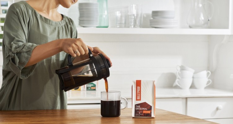 A woman pouring a mug of Bulletproof Original Coffee