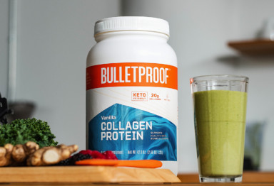 A large tub of Bulletproof Vanilla Collagen Protein next to a green smoothie