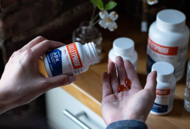 A hand pouring Bulletproof Vitamins A-D-K