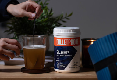A hand mixing Bulletproof Collagen Sleep Protein into a mug
