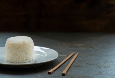 Cooked white rice on a plate with chopsticks