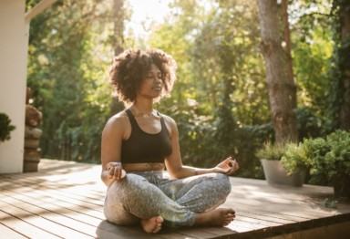 A black woman meditating outside