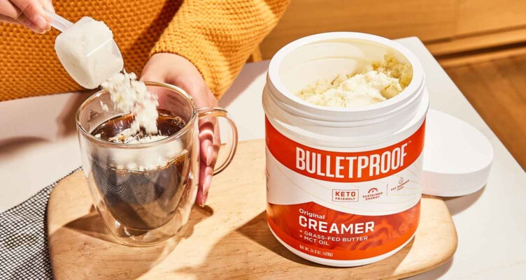 Hand scooping Bulletproof Creamer into coffee mug