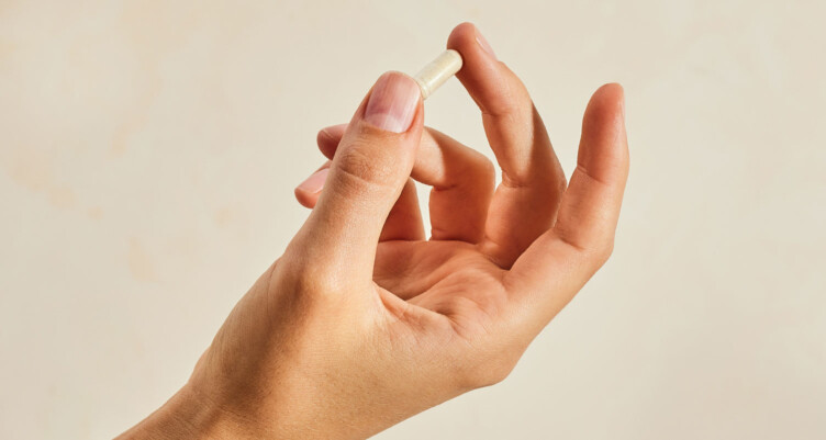 Hand holding Bulletproof Zinc with Copper supplement pill