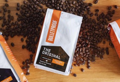 A bag of Bulletproof Original Coffee and scattered coffee beans