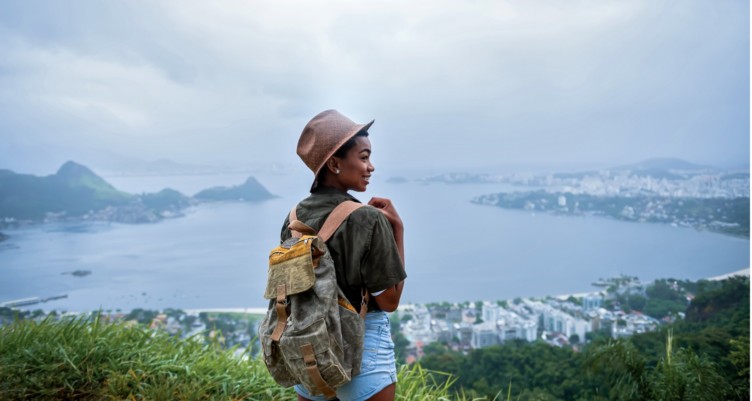 A girl smiles while standing on top of a hill