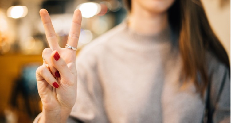Woman making the peace sign.