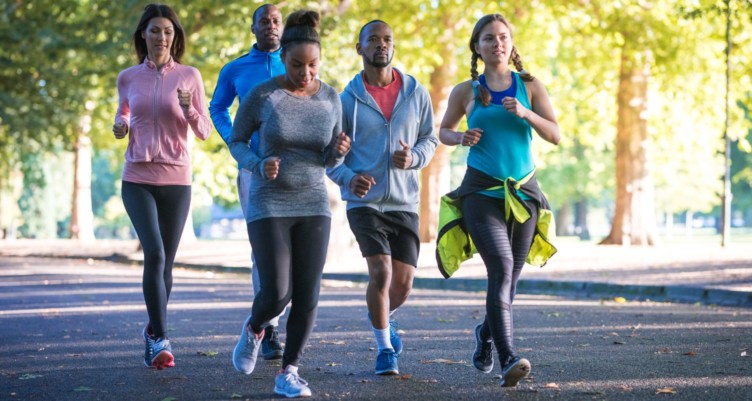 Group of people running together in a park.