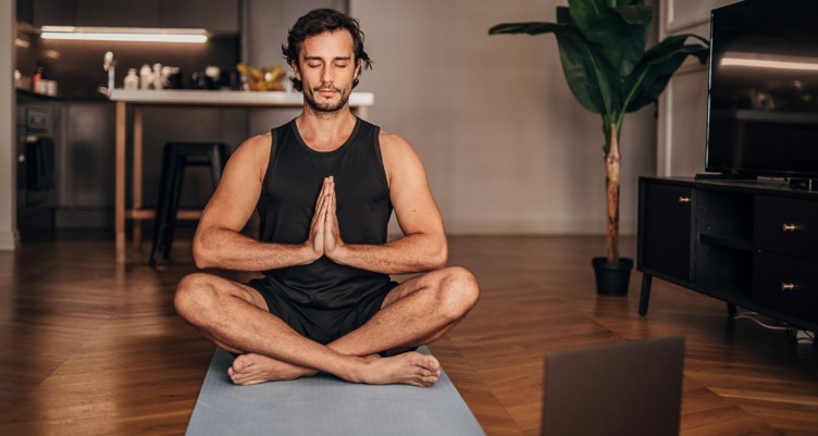 Man meditating in living room.