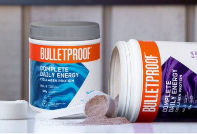 Two tubs of Bulletproof Complete Daily Energy, with one tub on its side spilling out product