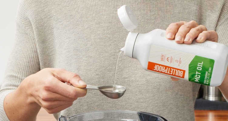 A hand pouring Bulletproof MCT Oil into a spoon