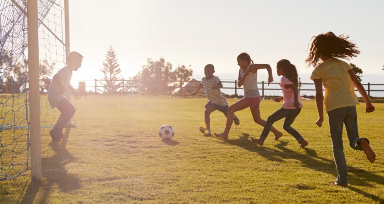 Kids playing soccer on field
