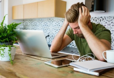 A man feeling overworked at his computer