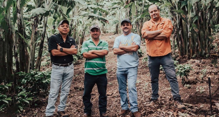 Coffee farmers posing for a picture in the forest.
