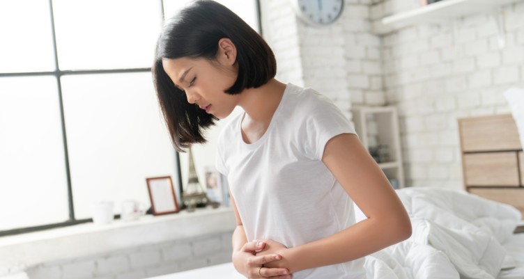 Woman holding her stomach in pain.