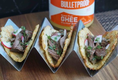 Lamb tacos with cauliflower tortillas in a silver holder with a jar of ghee