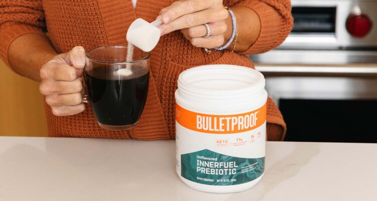 hand scooping Bulletproof Innerfuel Prebiotic into mug of coffee