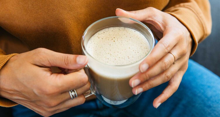 hands holding a creamy cup of Bulletproof coffee