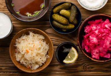 an overhead shot of good gut health foods like sauerkraut and pickled onions