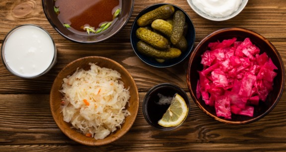 an overhead shot of good gut health foods like sauerkraut and pickled onions