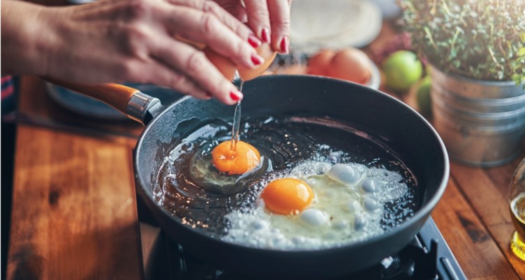 Cracking eggs into a frying pan