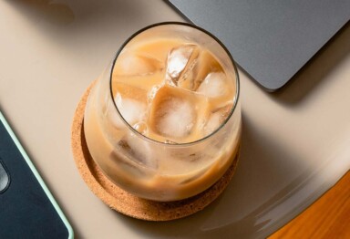 Overhead view of a cup filled with iced Bulletproof coffee on tabletop