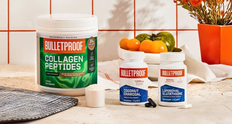 Bulletproof products on the counter with supplement capsules and a scoop of powder.