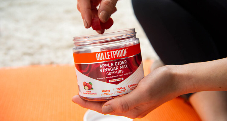 Hands holding jar of Bulletproof Apple Cider Vinegar Max Gummy Vitamins