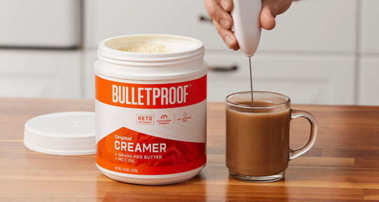 A hand frothing a cup of Bulletproof Coffee using the Original Creamer fomula