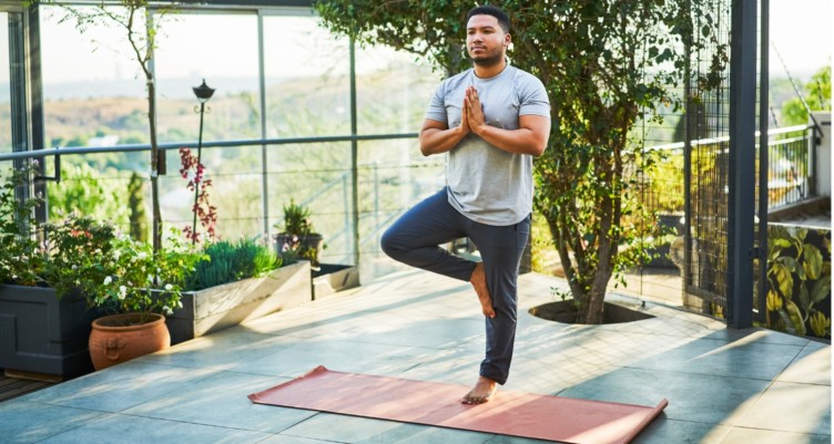 Man practicing yoga on exercise mat.