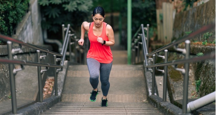 Woman running up flight of stairs for exercise.