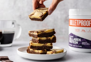stack of keto cheesecake brownies with Bulletproof product and coffee in background
